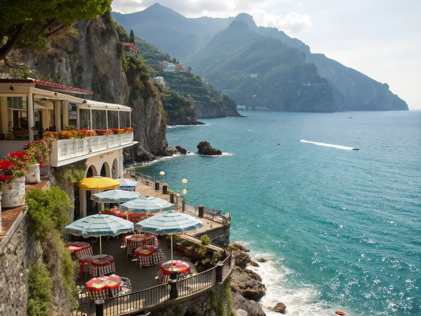 A picturesque view of Il San Pietro di Positano, showcasing its cliffside location, private beach, and lush terraced gardens overlooking the Tyrrhenian Sea.