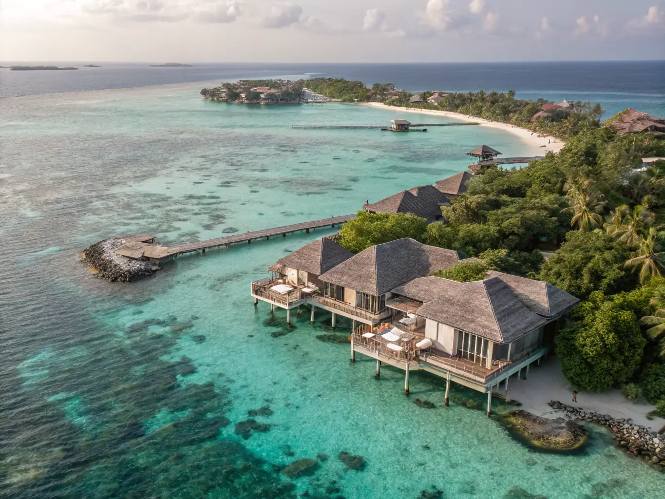 A luxurious overwater villa at Conrad Rangali Island in the Maldives, featuring twin beds and a stunning view of the turquoise lagoon. The villa is elegantly designed with modern amenities and traditional Maldivian touches, emphasizing the resort's commitment to providing separate sleeping arrangements for couples.